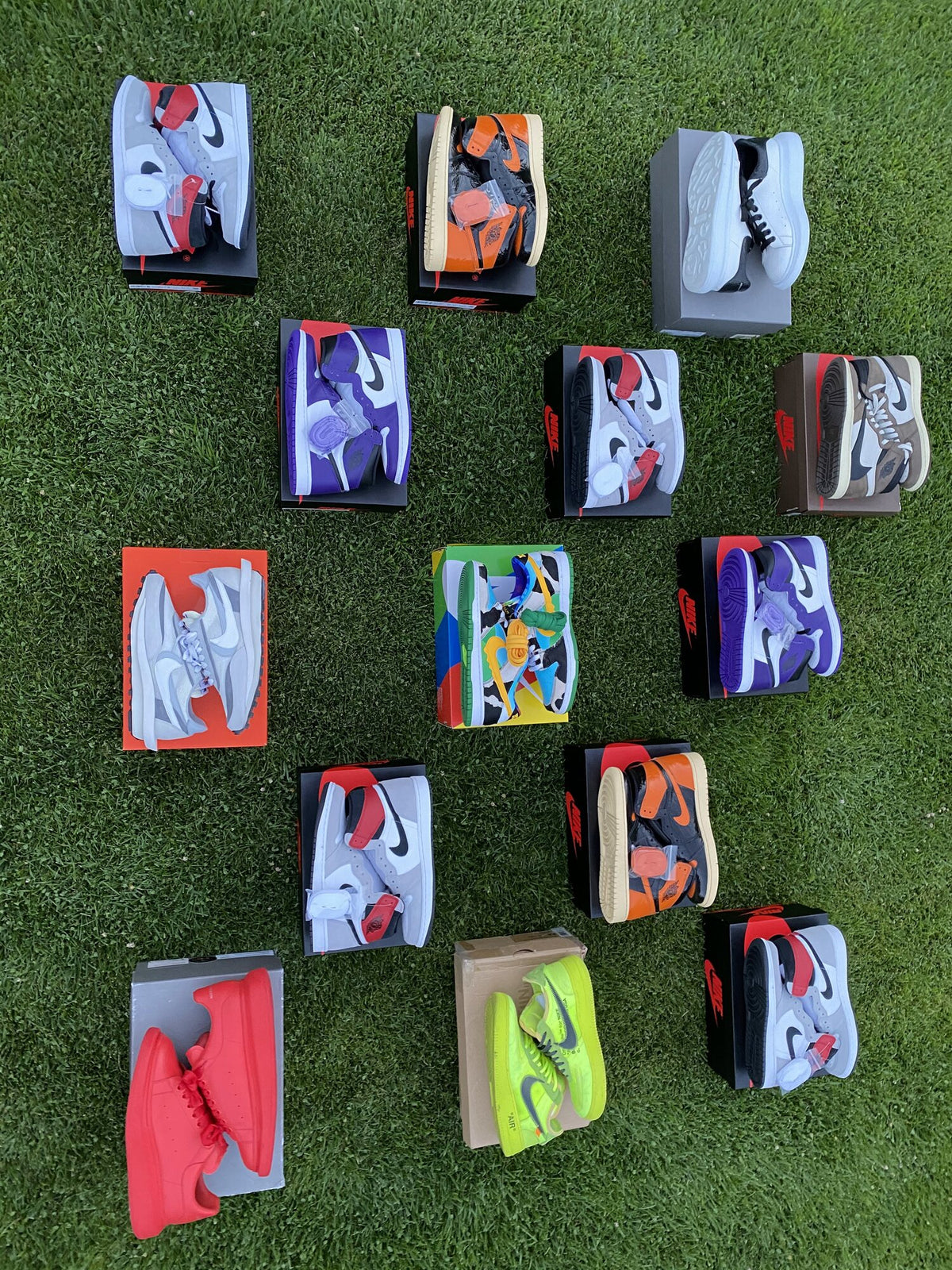 Limited-edition Nike and Jordan sneakers on their boxes on the grass, photographed for an early sales post
