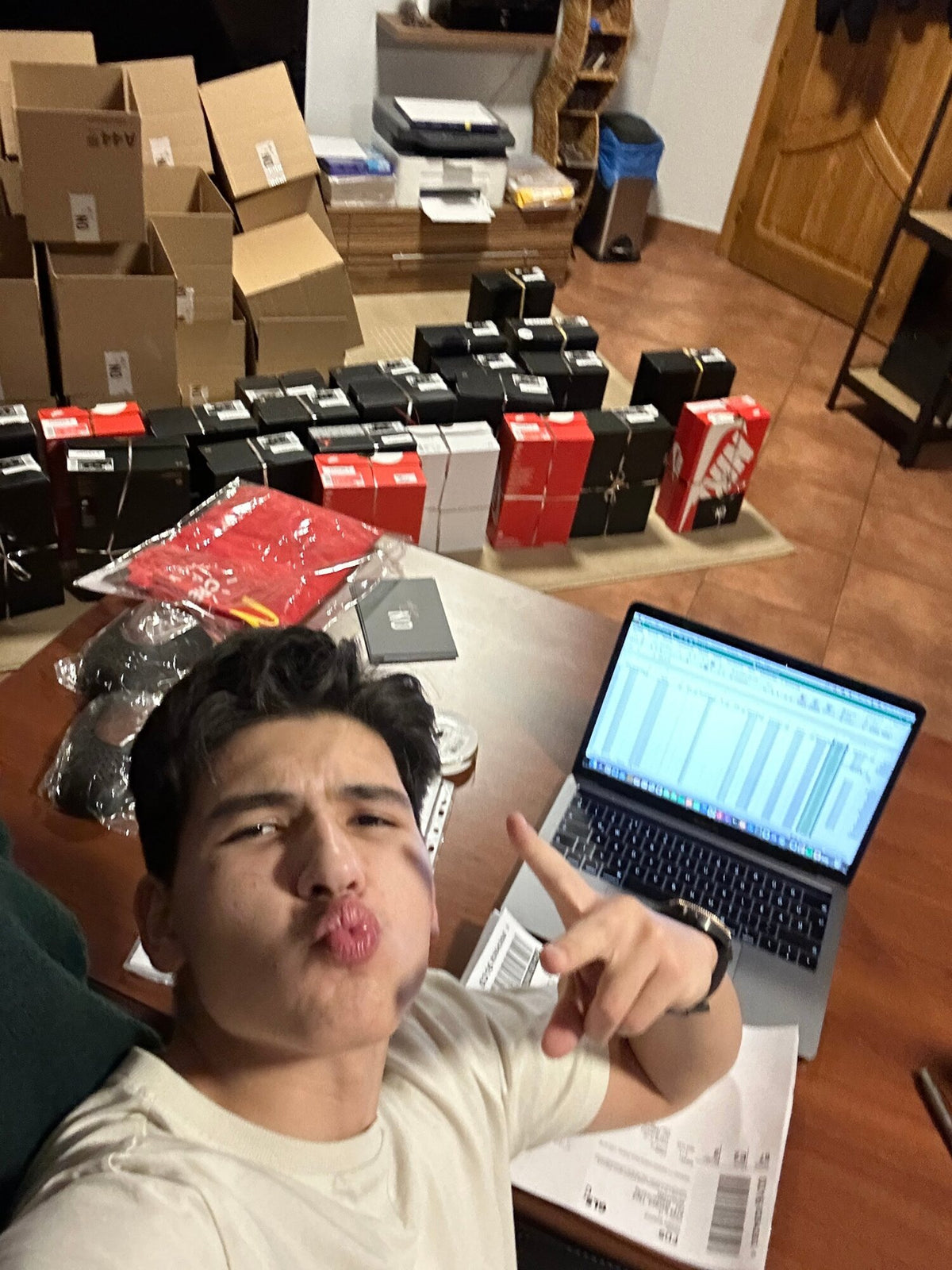 Selfie of Ádám Péter next to a laptop, shoeboxes and shipping labels