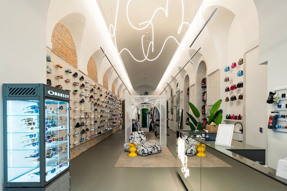 The store's long, vaulted space with sneaker walls and a lounge corner