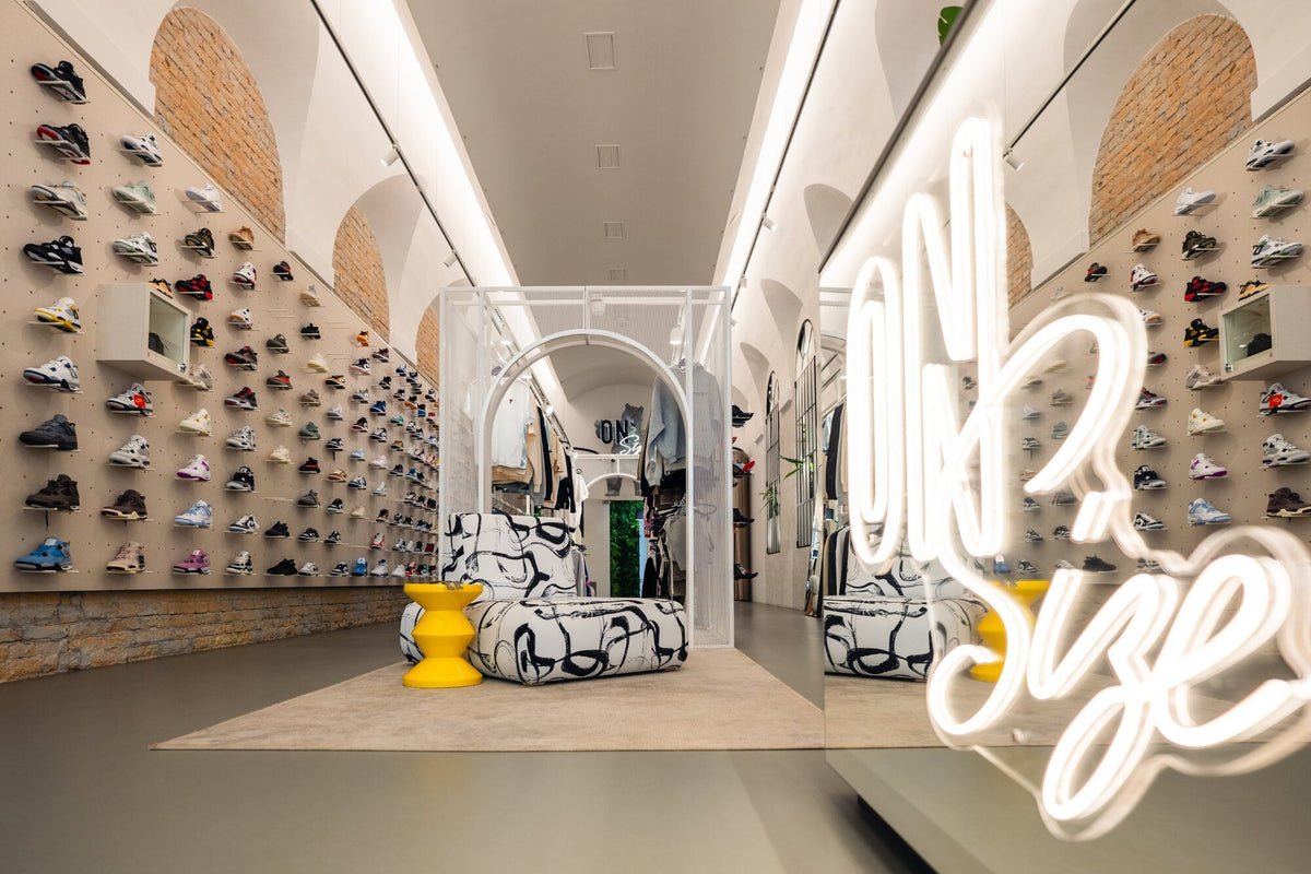A wall full of Jordan sneakers in the store, with the OnSize neon logo in the foreground