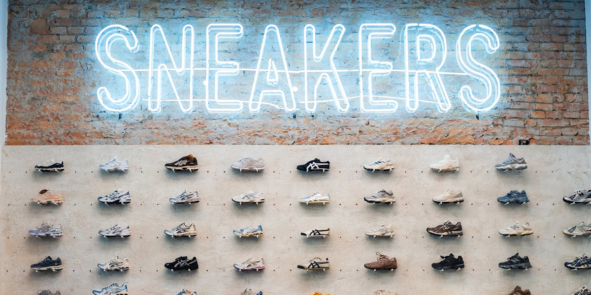 SNEAKERS neon sign on the brick wall, with sneakers lined up below